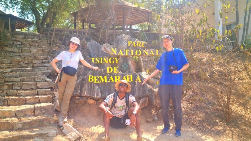 Three tourists posing at the entrance of Tsingy de Bemaraha National Park.