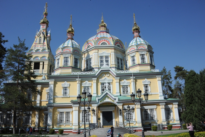 Colorful cathedral with ornate architectural details surrounded by trees
