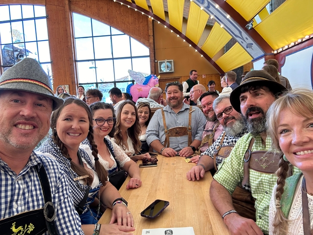 Group of people at a long table indoors, celebrating.