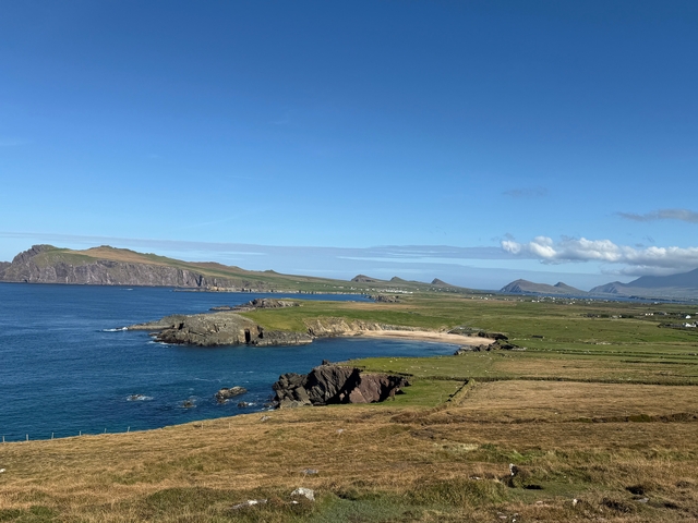       Coastal view overlooking a jutting peninsula and distant mountains.
  