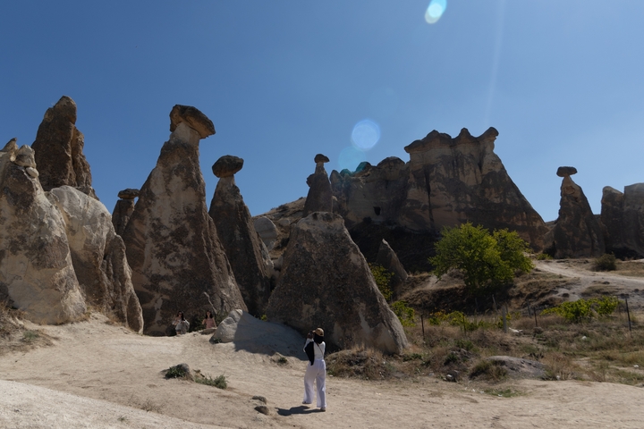Rock formations resembling fairy chimneys under a blue sky.
