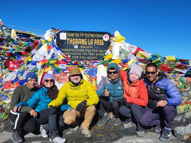 Group of people at Thorong La Pass with prayer flags