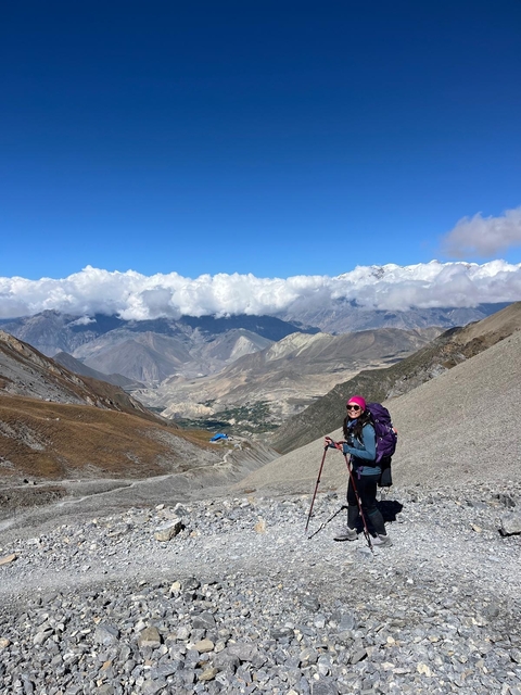 Hiker with trekking poles in a mountainous landscape