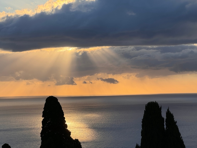       Sunbeam breaking through clouds over the ocean
  