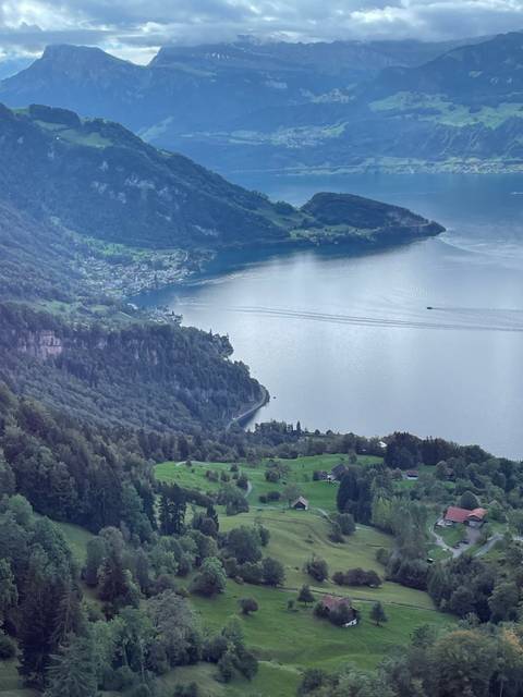 Scenic view of a lake with a winding road and scattered houses
