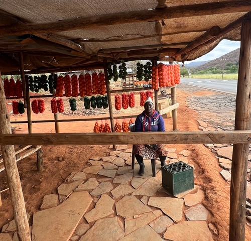 Person selling fruits at a roadside stall