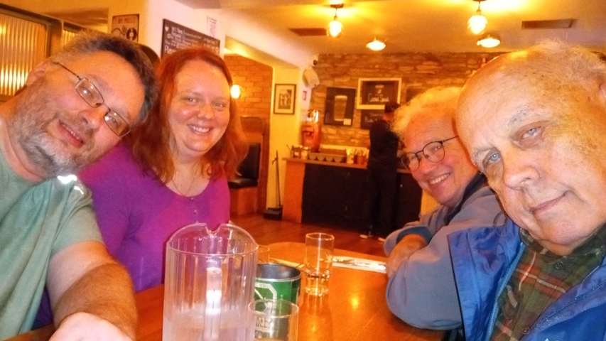 Group of people seated indoors enjoying drinks.