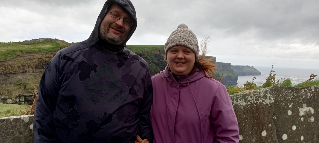       A couple posing at the Cliffs of Moher.
  