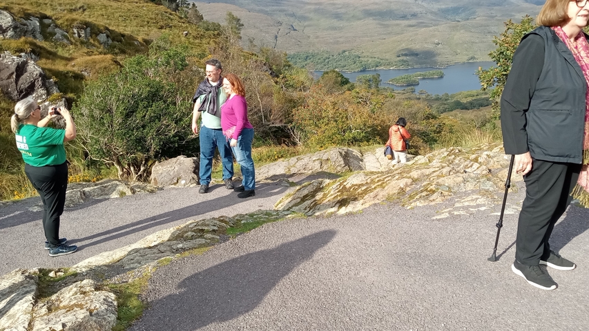       Group of people posing with a scenic mountain view.
  