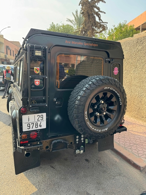       Back of a black off-road vehicle with license plate.
  