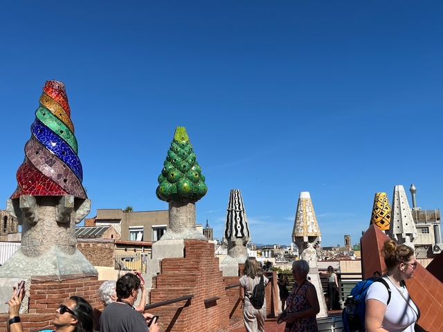 Colorful mosaic chimneys on a rooftop, iconic Gaudi design.