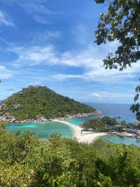      A postcard view over turquoise bays and the sandbar connecting a lush little island to the mainland.
  