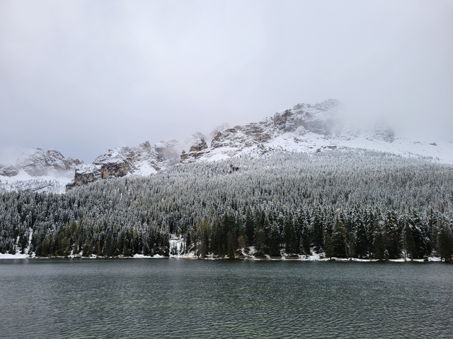 Snowy mountain range overlooking a peaceful lake.