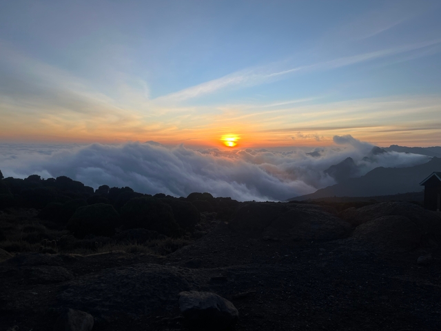 A breathtaking view of a sunset with clouds over the horizon.