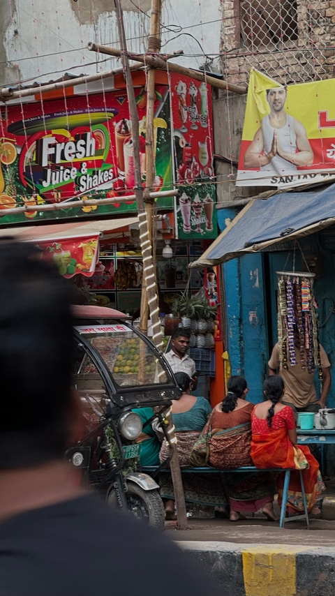 A blurry street view with shops and people.