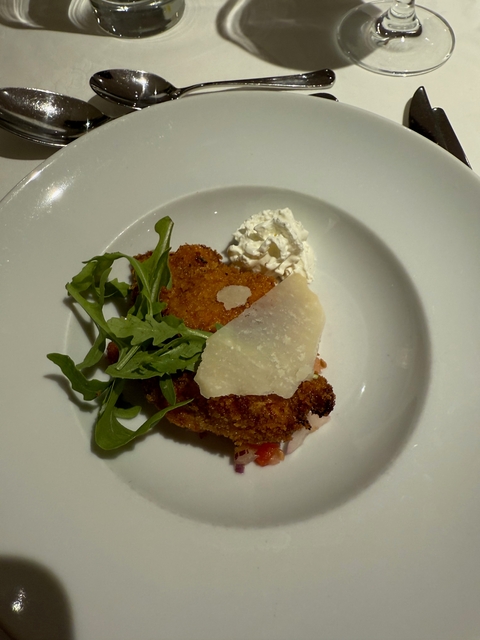 Breaded chicken with cheese over salad greens