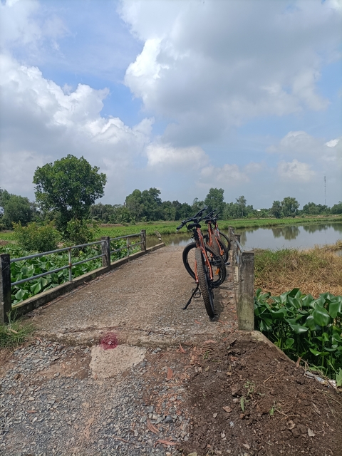       Two bikes parked on a bridge by a river.
  