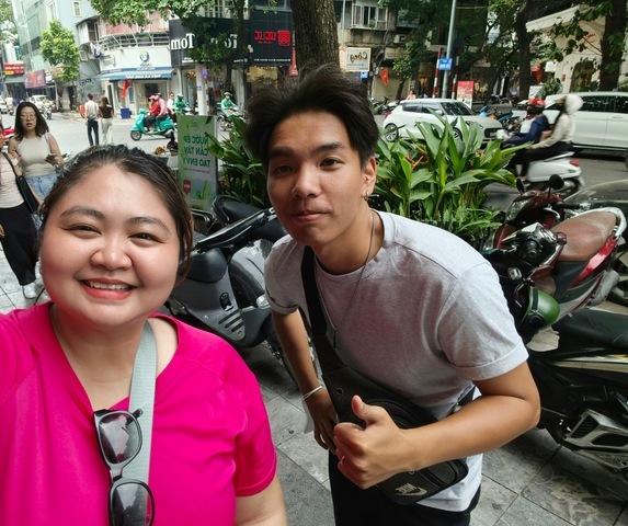 People taking a selfie on a busy street.