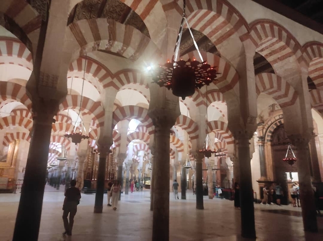       Interior of a mosque with arches and columns.
  