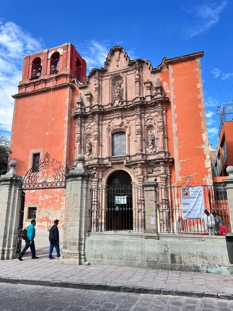 Rustic pink church with decorative facade.