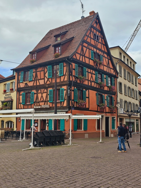 Half-timbered building decorated with flowers in a charming setting.