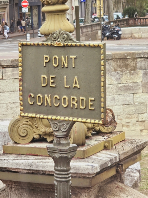 Signboard showing 'Pont de la Concorde' in a city.