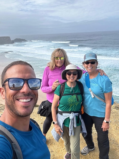 Group of people posing with an ocean backdrop