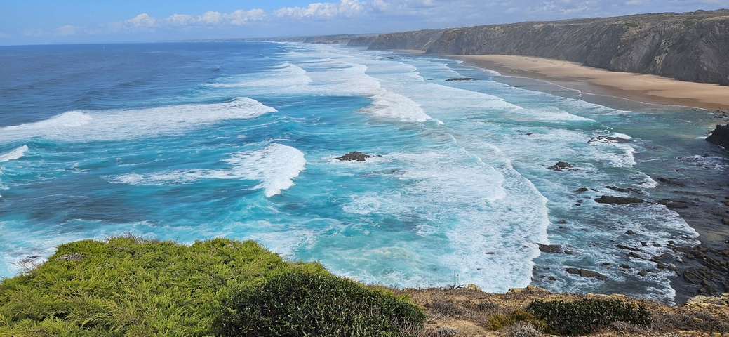 Waves crashing onto a vast coastal beach