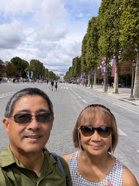 People posing on a wide street with trees and banners in the background