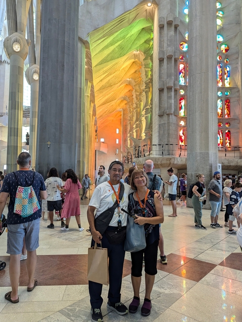 People inside a large cathedral with colorful stained glass windows
