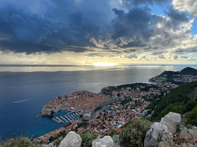      Aerial view of Dubrovnik with the ocean and dramatic sky.
  