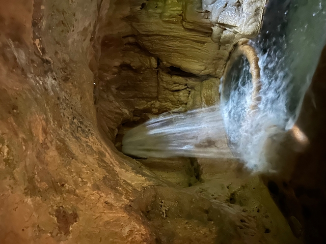       Cave with a waterfall and flowing water.
  