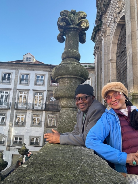 Two people smiling with old European architectural background.