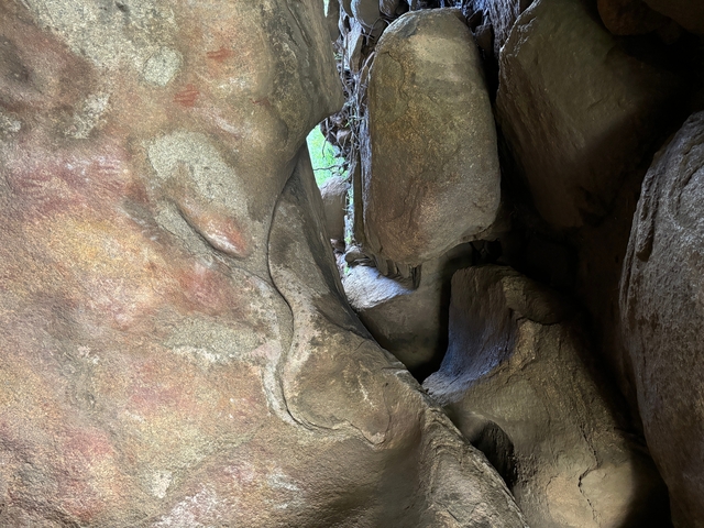       Inside a rock crevice with natural light filtering through.
  