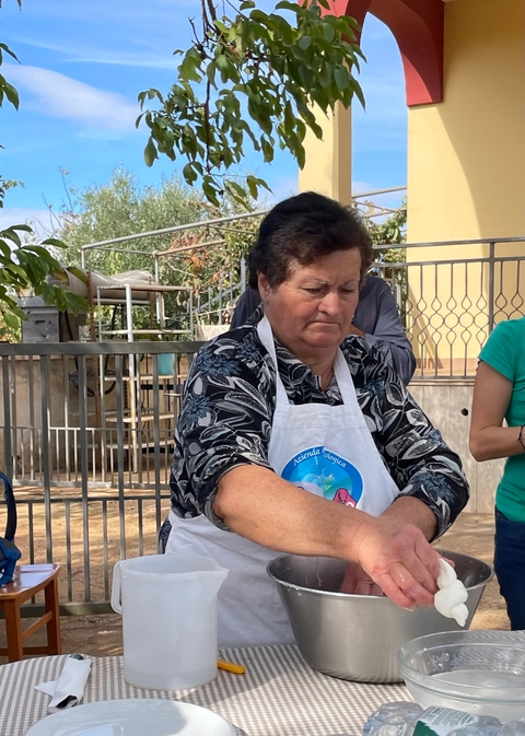       Woman concentrating on dough preparation outdoor.
  