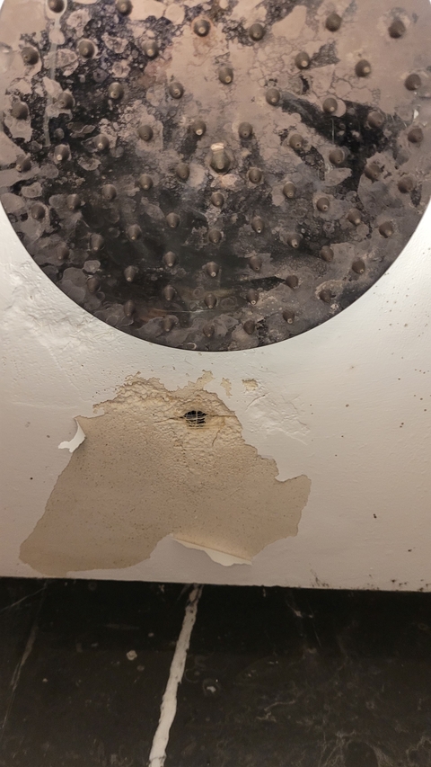 Damaged ceiling with a hole and rust.