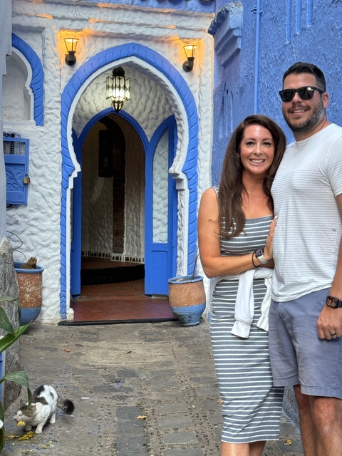 Couple standing in front of a building with blue and white features.