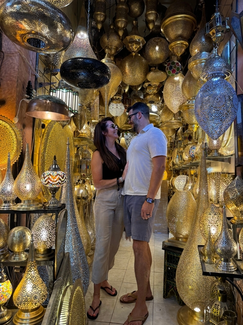 Couple standing inside a shop filled with decorative lamps.