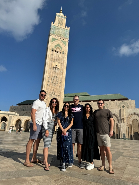 Group of people posing in front of a mosque.
