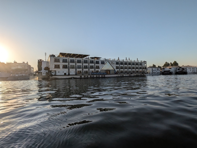 River cruise ship on water during sunset.