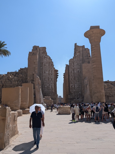 People visiting ancient ruins of an Egyptian temple.