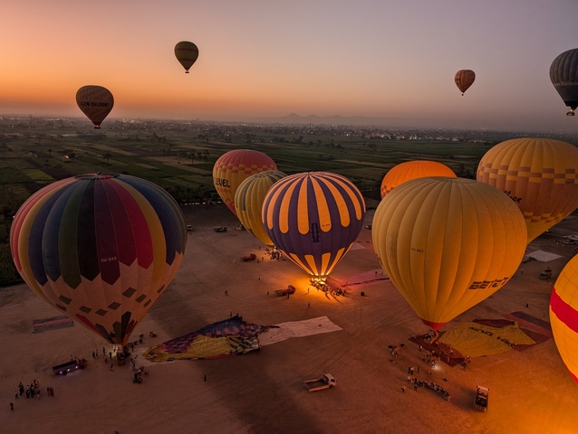 Hot air balloons preparing for launch at sunrise.