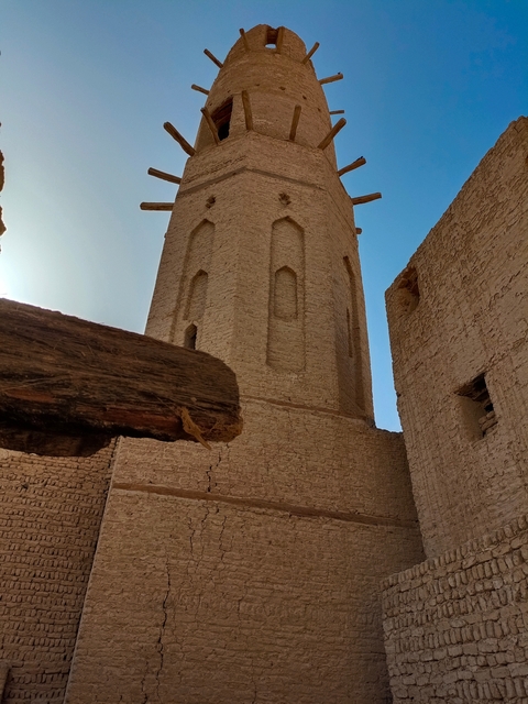       Brick tower and walls with clear sky.
  