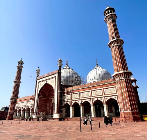       View of a mosque with multiple domes and a large courtyard.
  