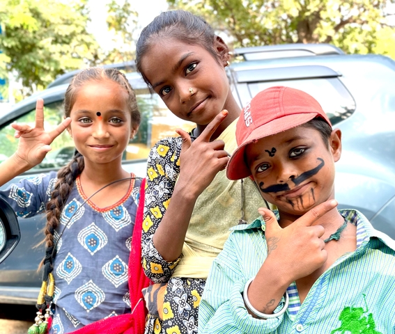       Three children with face paint smiling and posing.
  