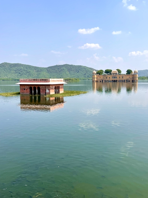       Water palace with calm reflections on a lake under a clear sky.
  