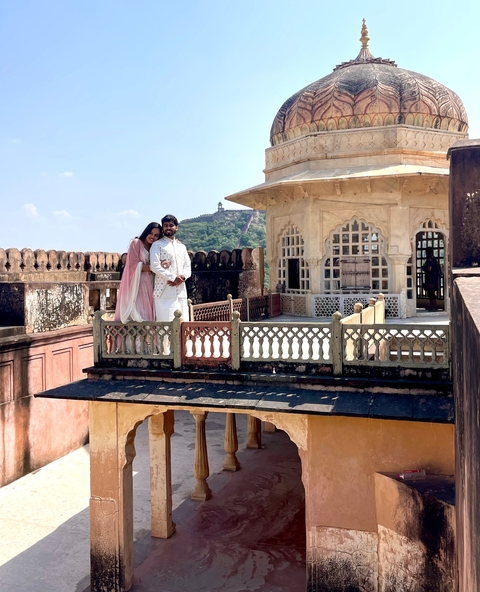       Couple posing on a historic balcony with scenic vistas.
  