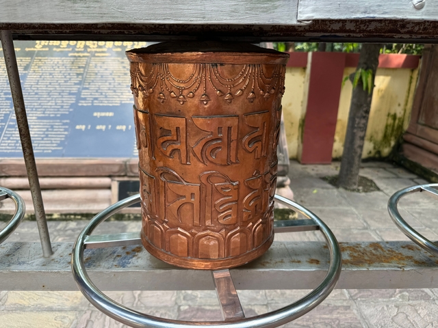 Close-up of a copper prayer wheel with inscriptions