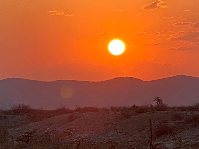       Sunset over mountains with a clear sky.
  