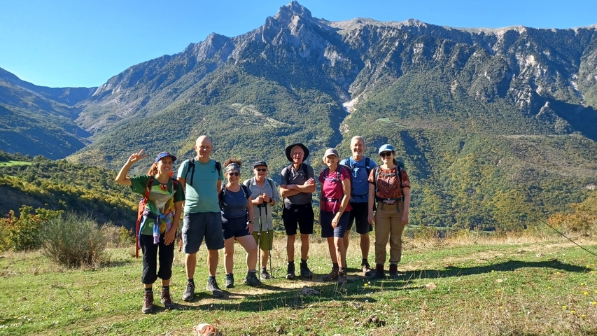       Group of hikers posing with a mountain backdrop.
  